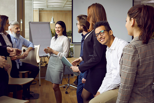 Team of happy diverse people having fun at work after business training or corporate meeting