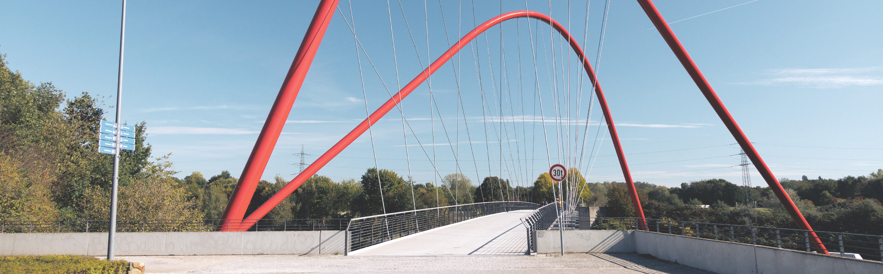 Rote Brücke über eine Straße, blauer Himmel
